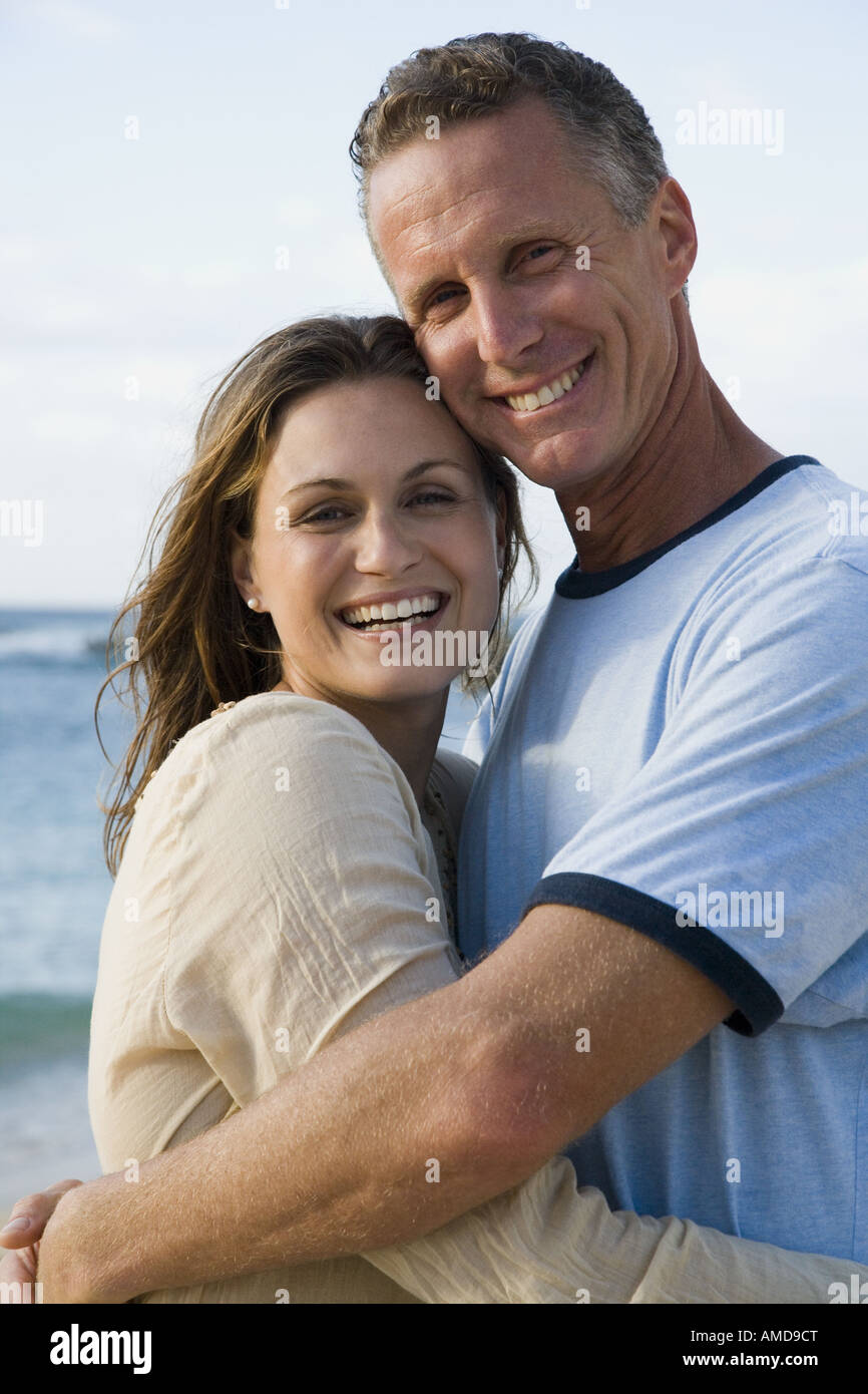 Man and woman hugging outdoors on beach smiling Stock Photo - Alamy