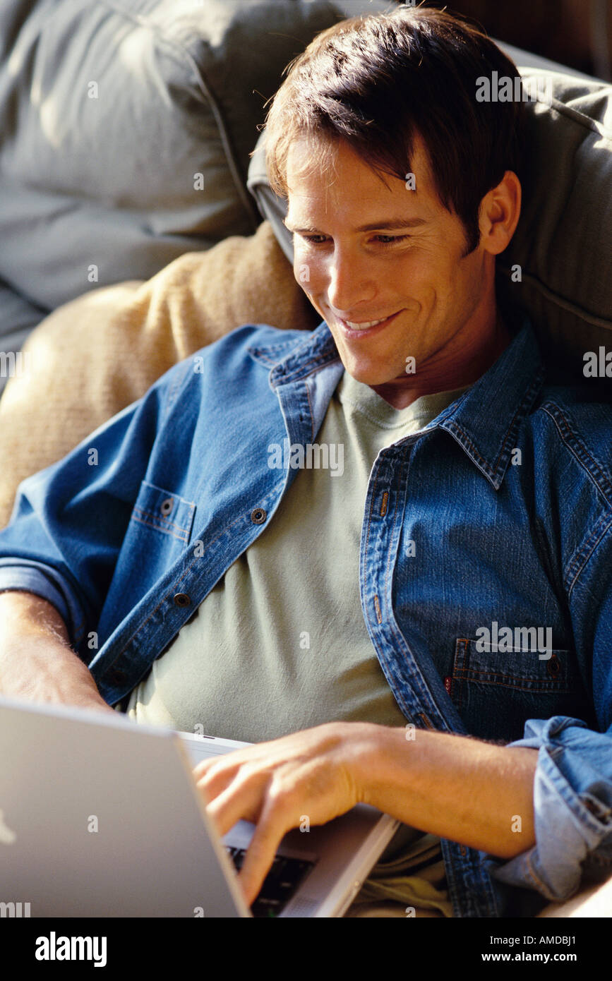 Man Sitting on Sofa Using Laptop Computer Stock Photo