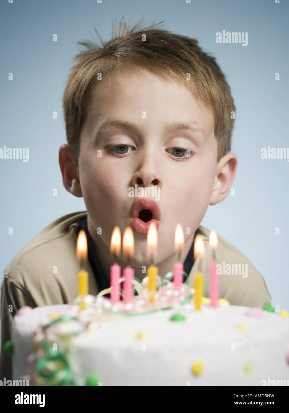 Boy blowing out candles on a birthday cake Stock Photo Alamy