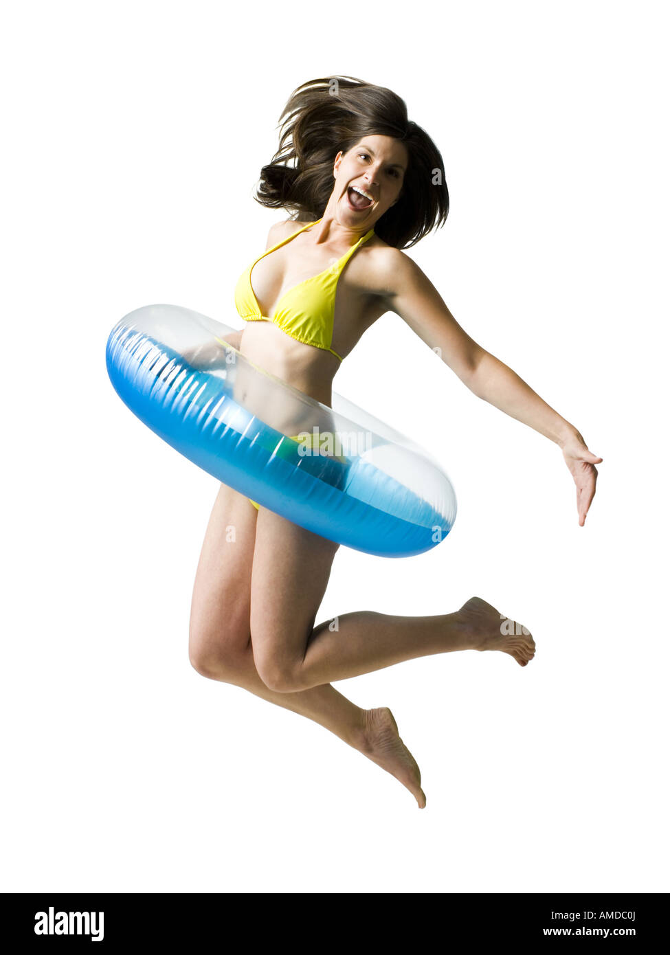 Woman in bikini with swimming ring around waist jumping and smiling Stock Photo