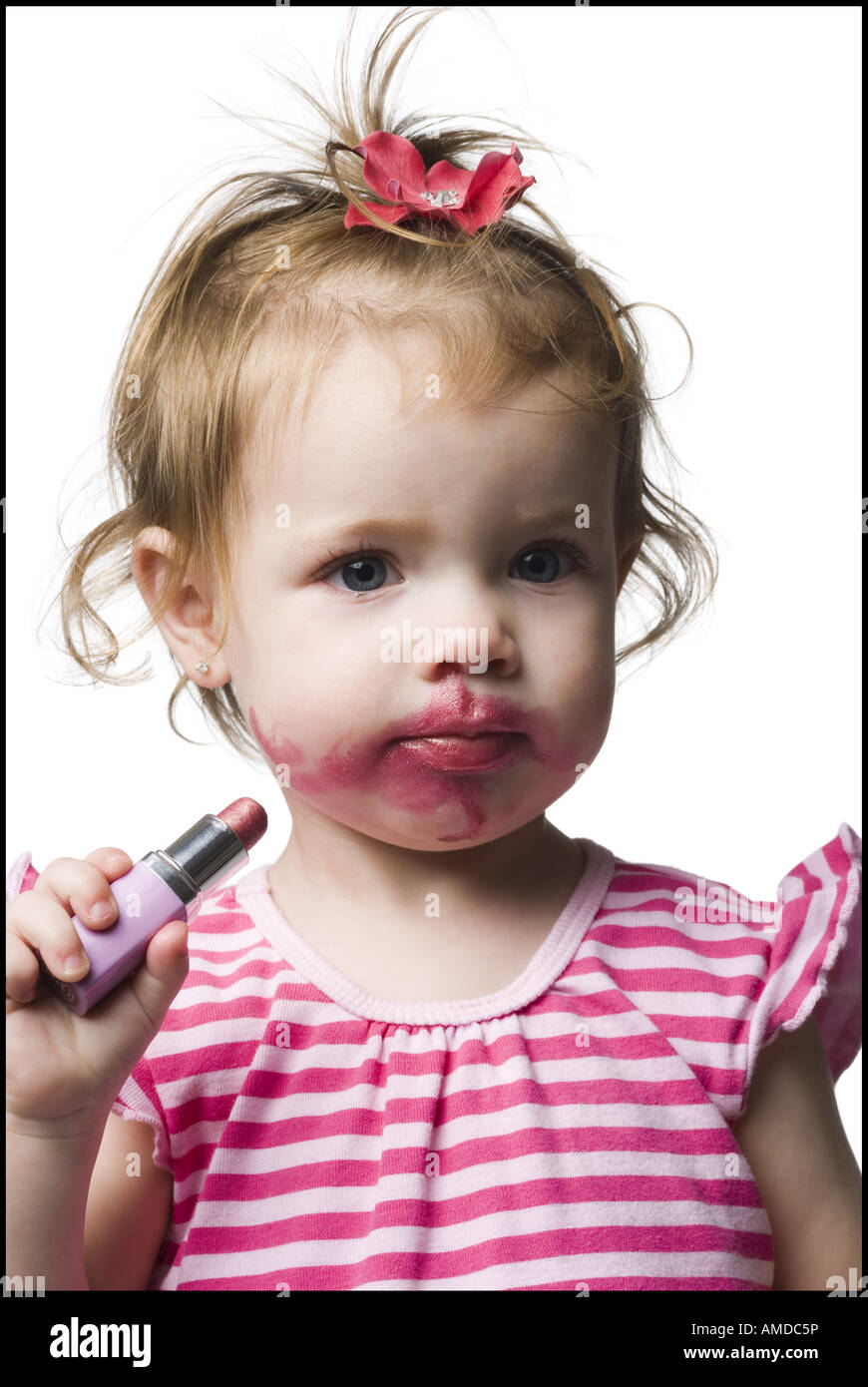 Girl with tube of lipstick and lipstick on face Stock Photo
