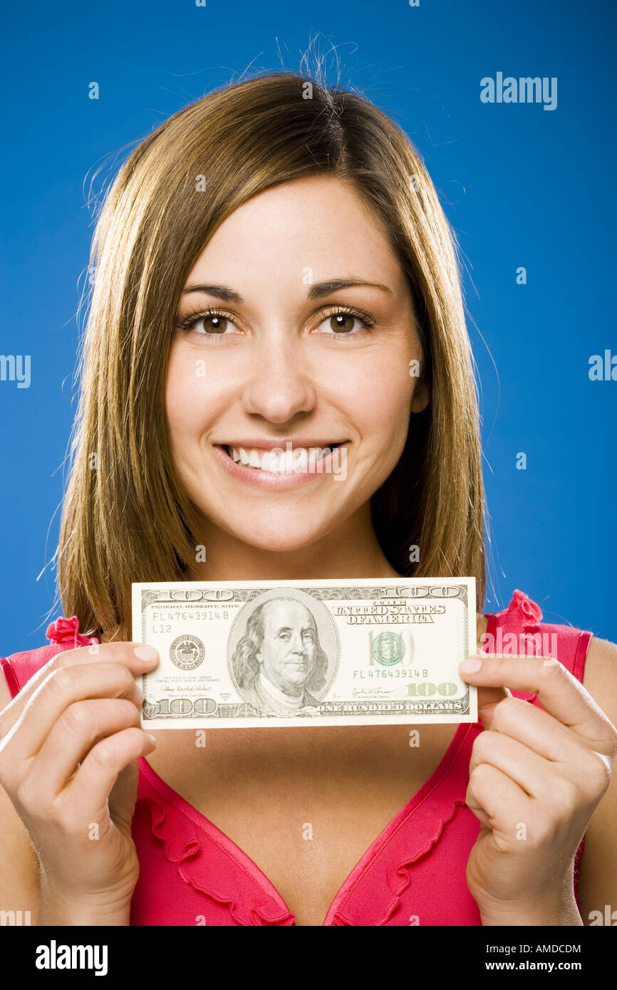 Woman holding one hundred American dollar bill smiling Stock Photo