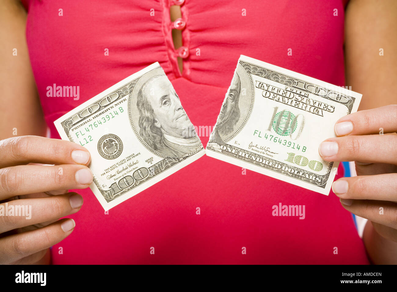 Woman tearing American hundred dollar bill Stock Photo