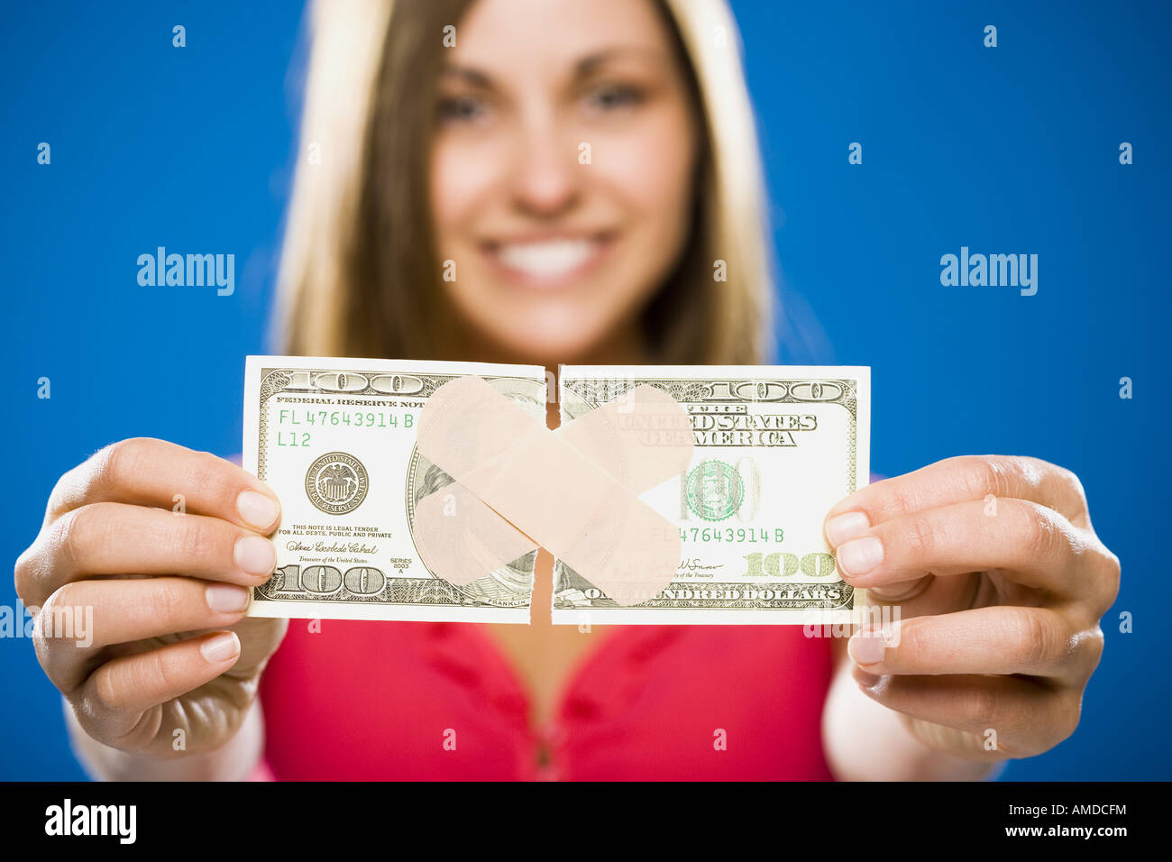 Woman with torn one hundred dollar American banknote with plastic strip Stock Photo