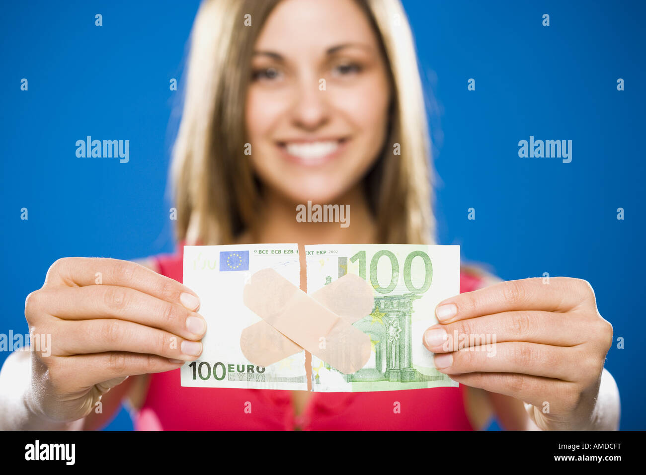 Woman with torn one hundred dollar euro banknote with plastic strips Stock Photo