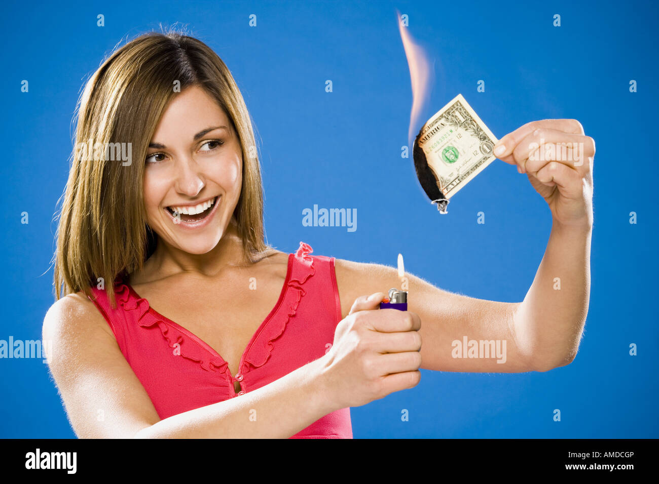 Woman setting American one dollar bill on fire Stock Photo