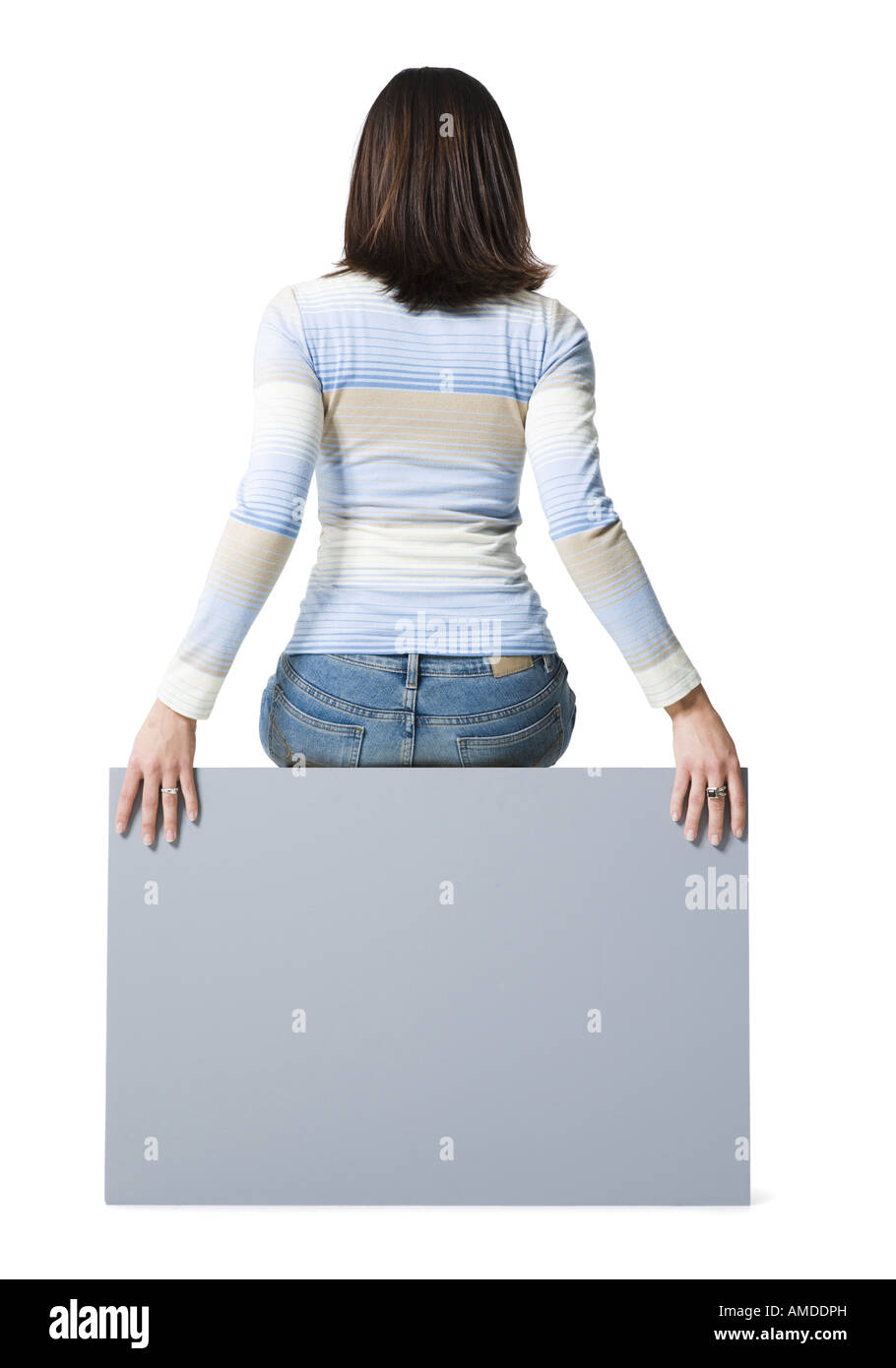 Rear view of woman sitting on blank sign Stock Photo