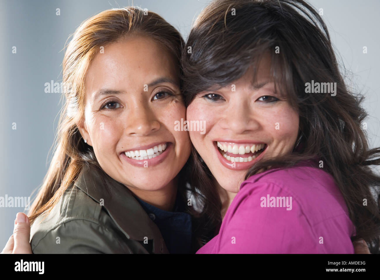 Portrait of mid adult women hugging each other Stock Photo - Alamy