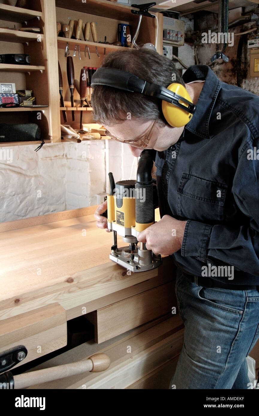craftsman-in-woodwork-shop-using-electronic-plunge-router-to-cut-a