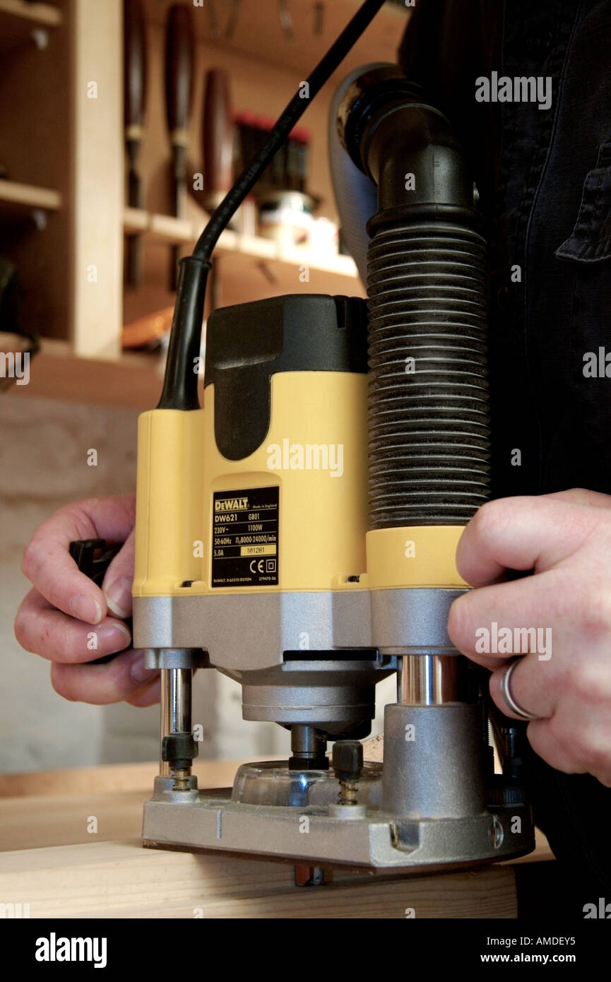 craftsman-in-woodwork-shop-using-electric-router-to-cut-a-rebate-in-a