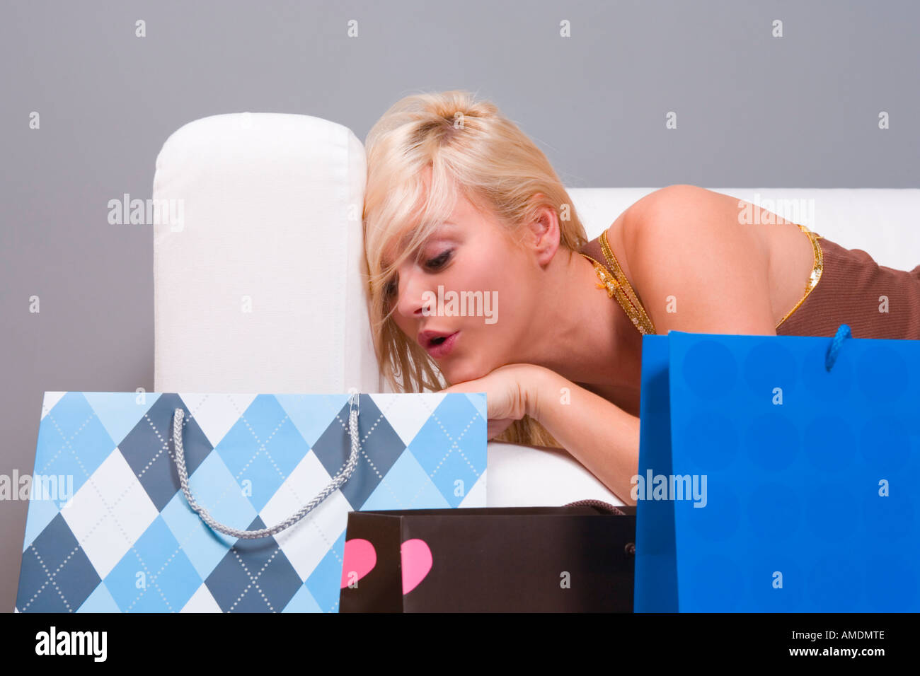 Woman peeking inside shopping bag Stock Photo