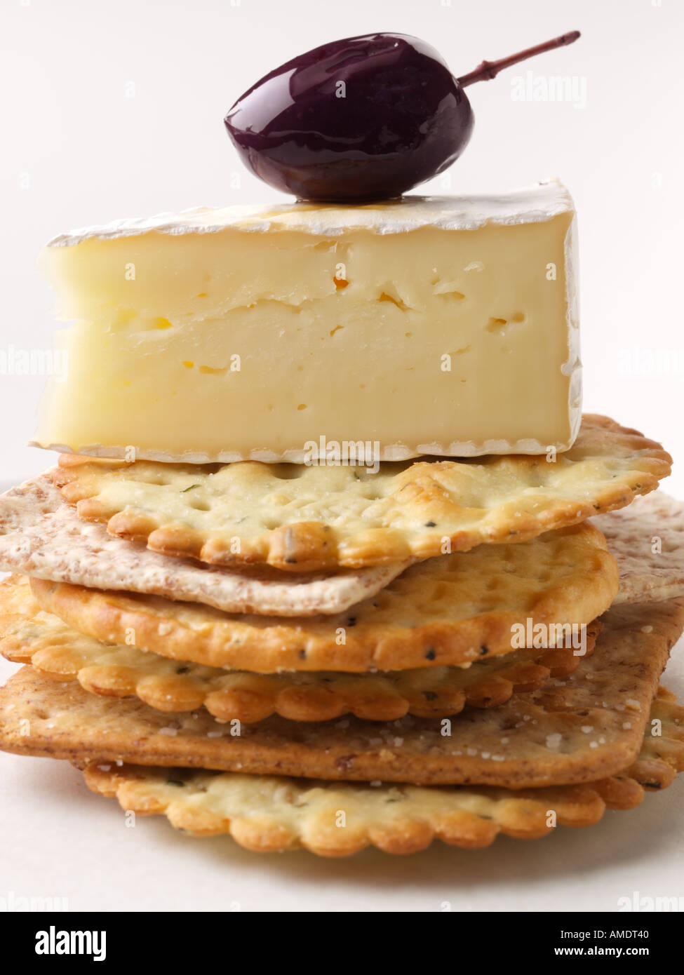 Black olive brie cheese wedge piled up crackers hires stock