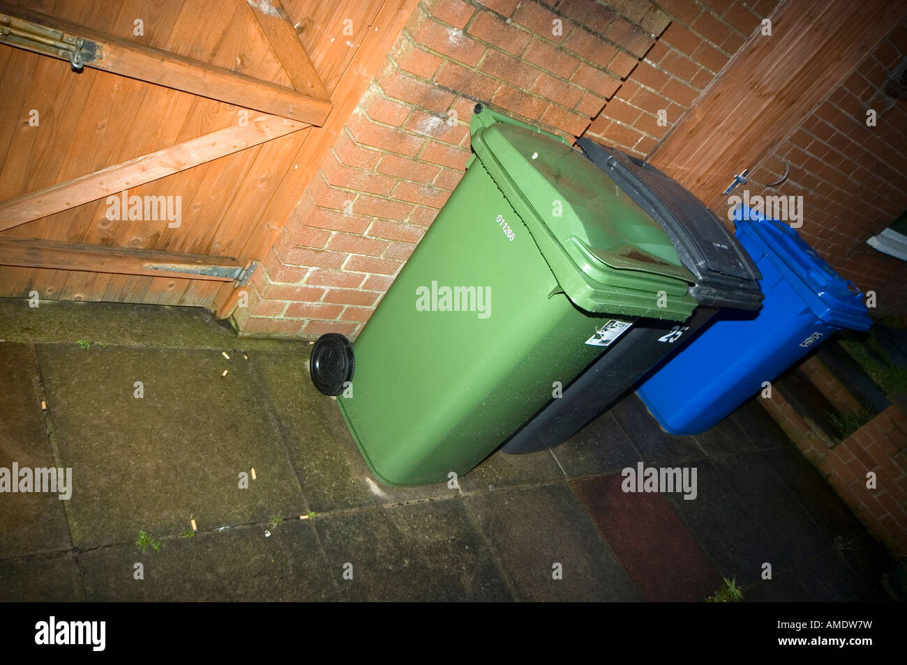 Wheelie bins lined up against a garage Stock Photo Alamy