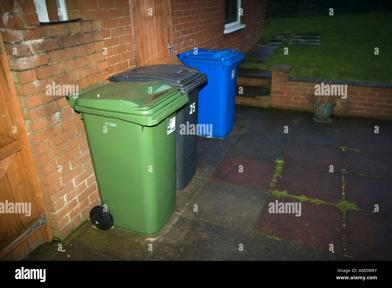 Wheelie bins lined up against a garage Stock Photo Alamy