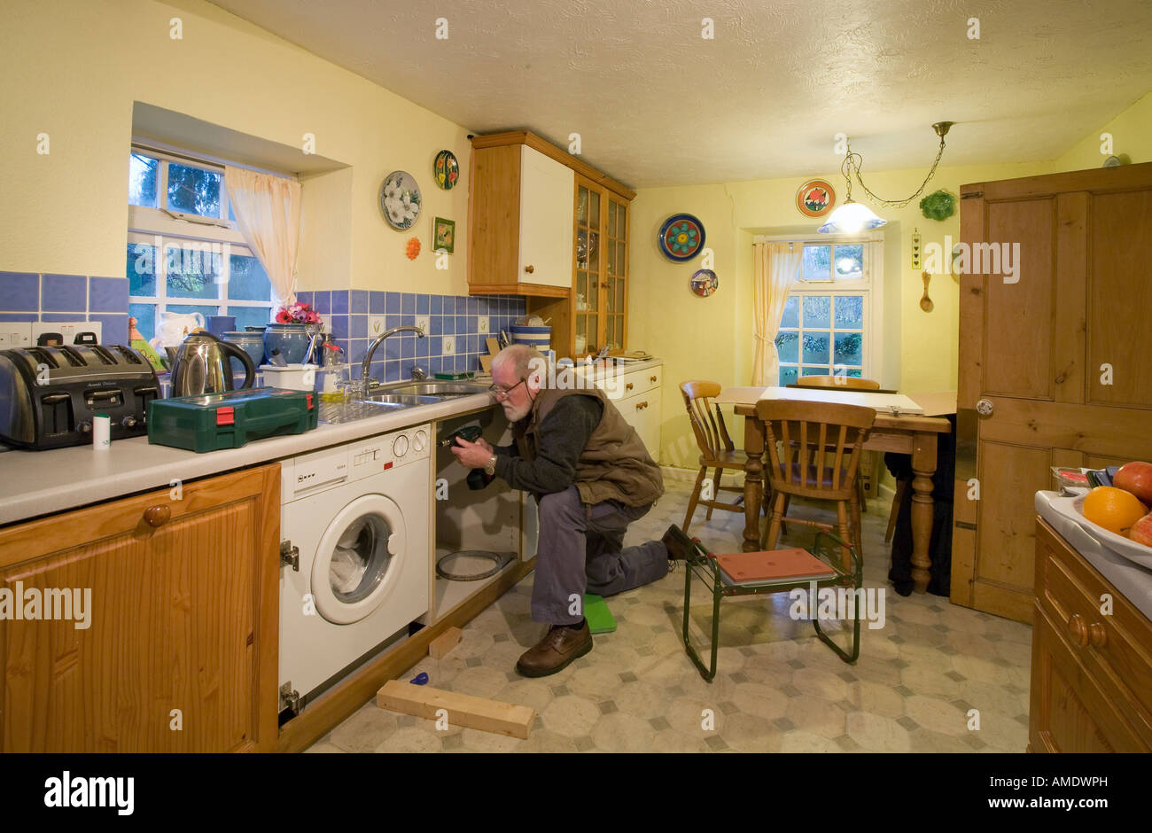 WORKMAN FITTING NEW KITCHEN IN COUNTRY COTTAGE Stock Photo Alamy