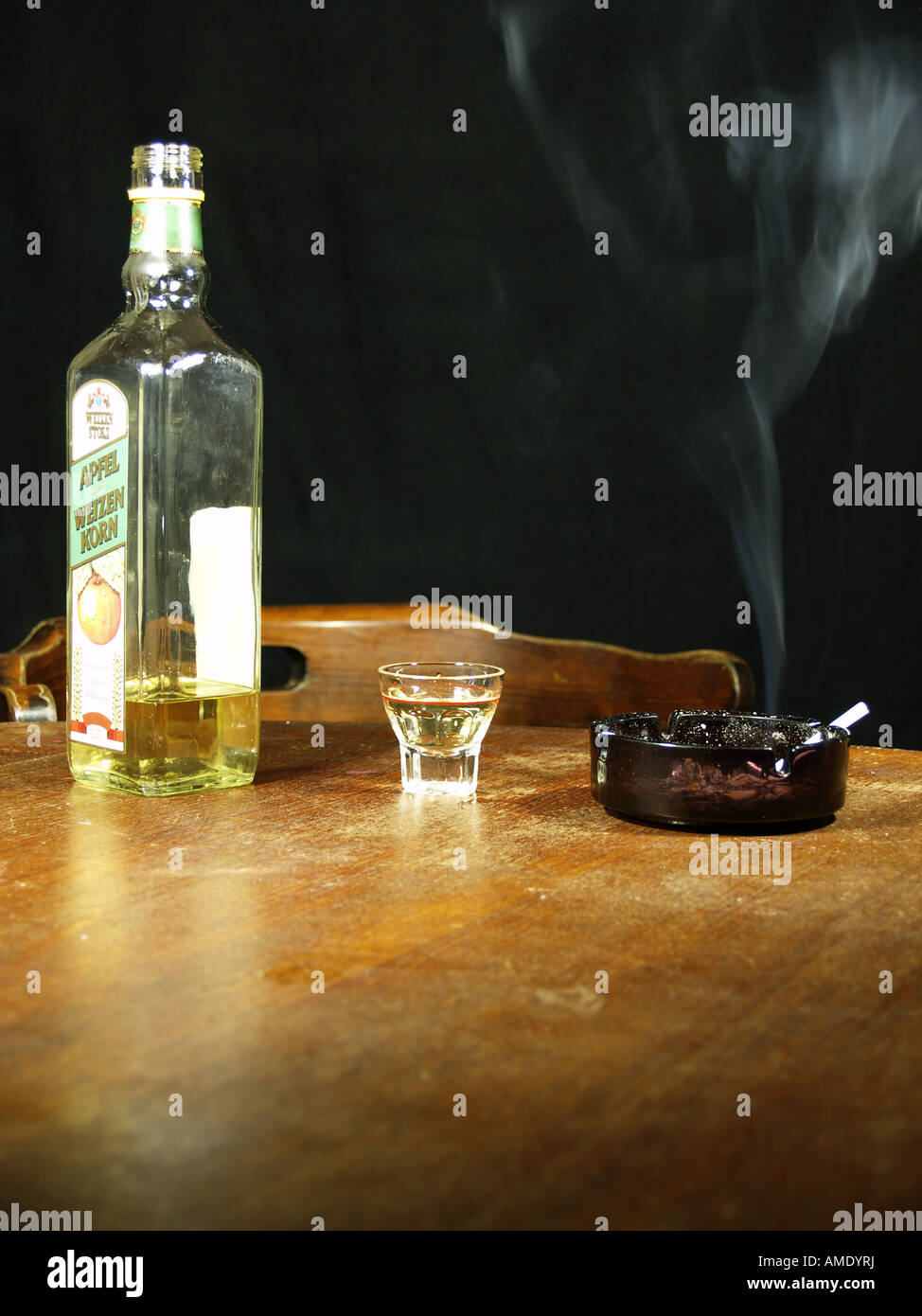 Drinking Schnapps and a smoking cigarette in a darkened bar Stock Photo