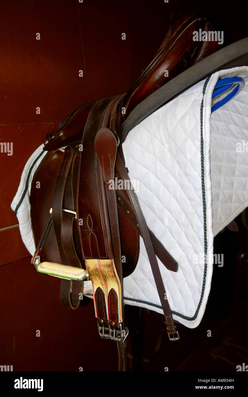 Saddle on a rack in a tack room horseback riding equipment Stock Photo