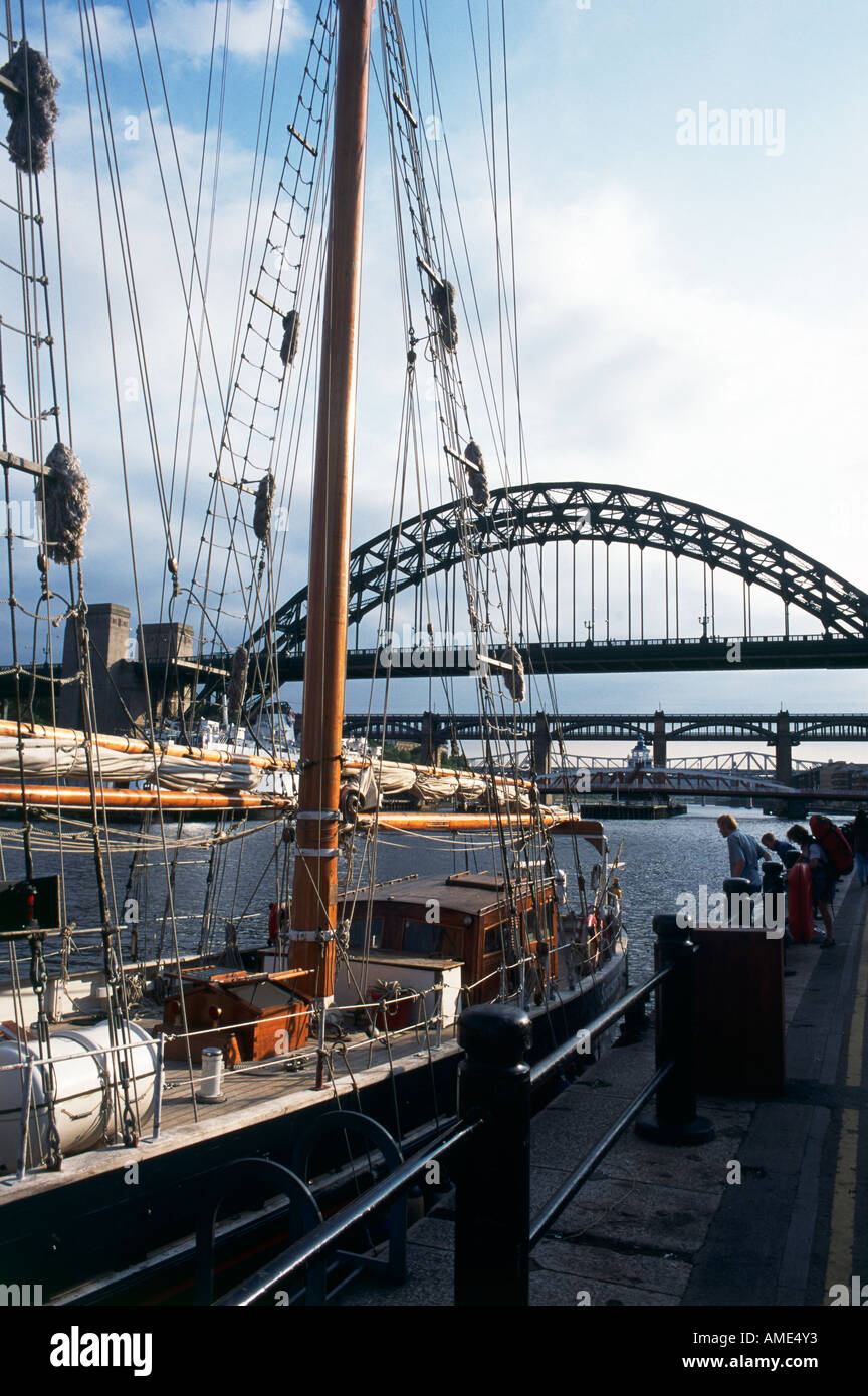 A sailing ship docked on the River Tyne which is spanned by many