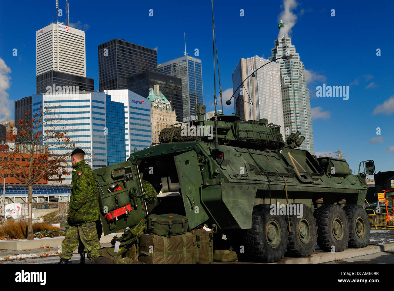 Soldier stocking Coyote Light Armoured Vehicle with Toronto city skyline financial tower high-rise buildings Stock Photo