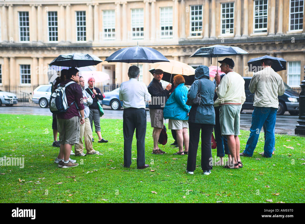 Visitors with a Tour Guide brave the changeable English weather in the Circus, Bath, Somerset, United Kingdom Stock Photo