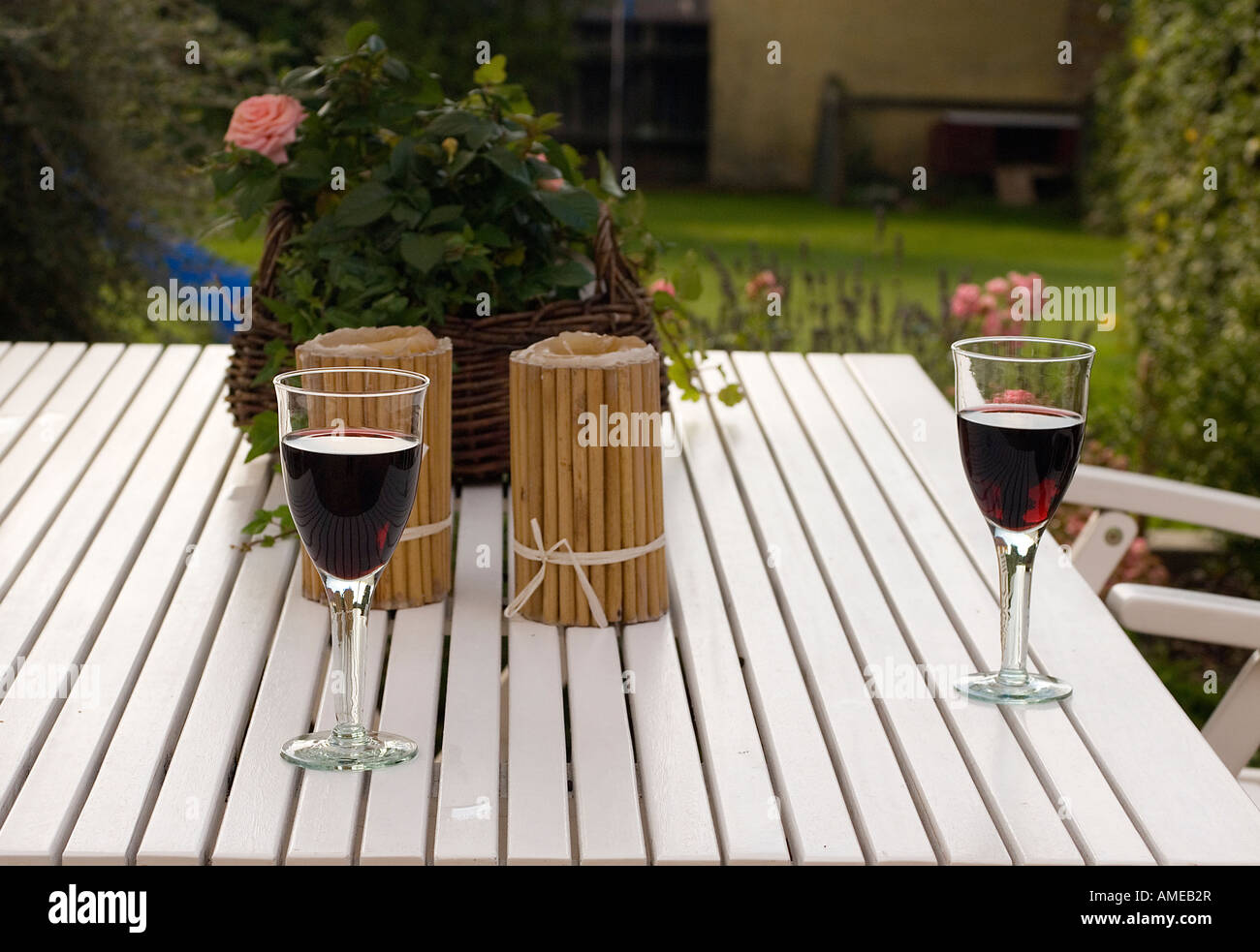 Garden table with glasses of redwine Midsummer atmosphere Stock Photo