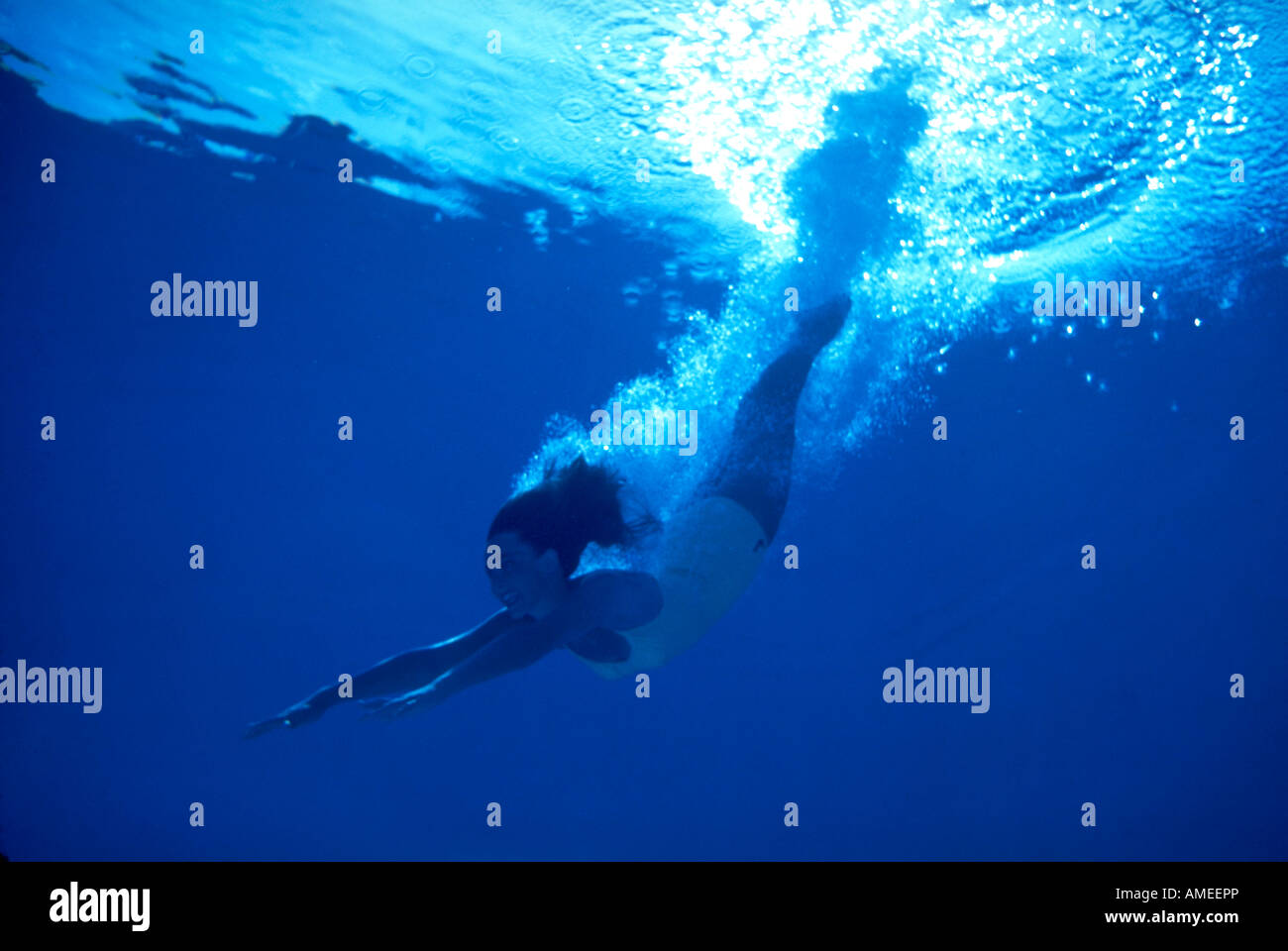 girl diving underwater in cloud of bubbles Stock Photo