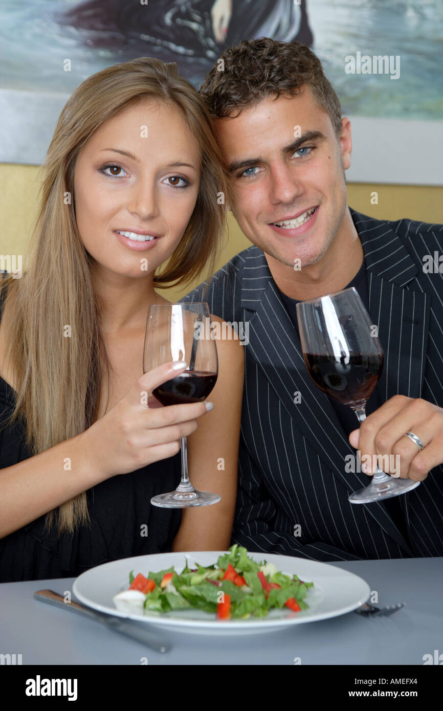 young couple raising vine glasses Stock Photo