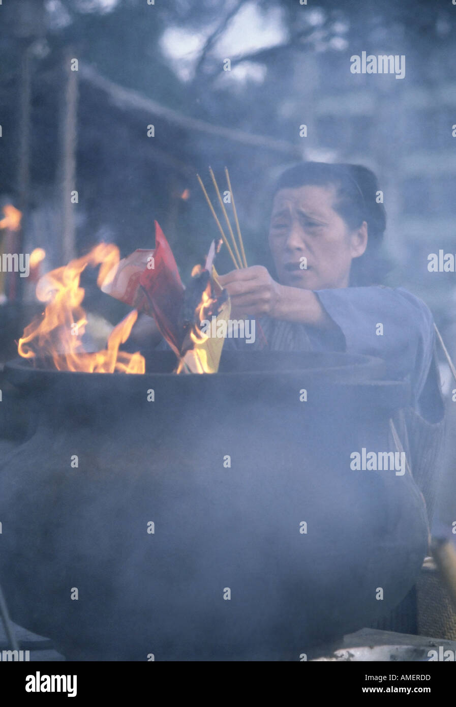 Woman burning incense in Kowloon Temple Stock Photo