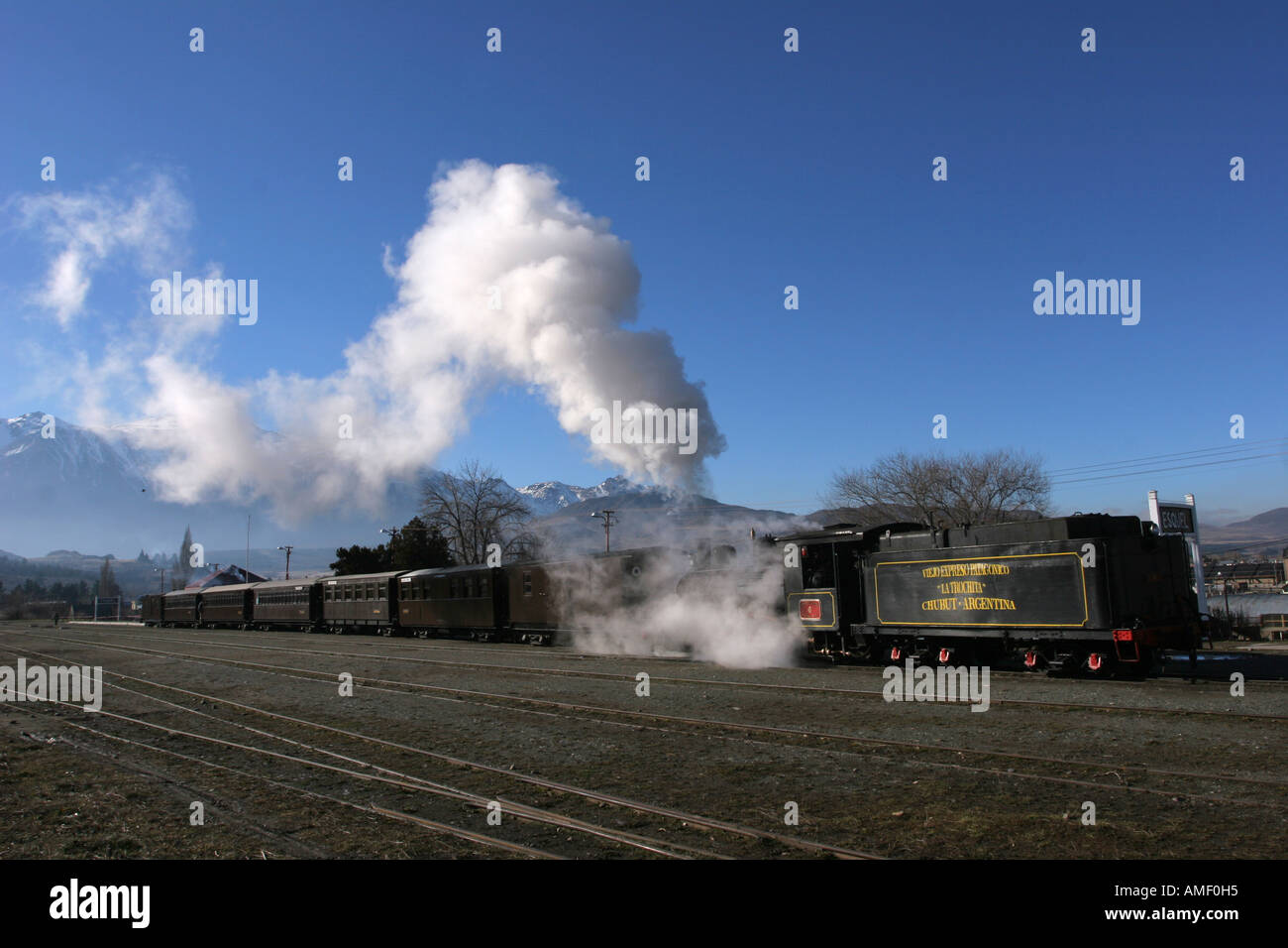 Old steam train La Trochita leaving the station of the town of Esquel, Chubut, Patagonia, Argentina, and throwing a lot of steam Stock Photo