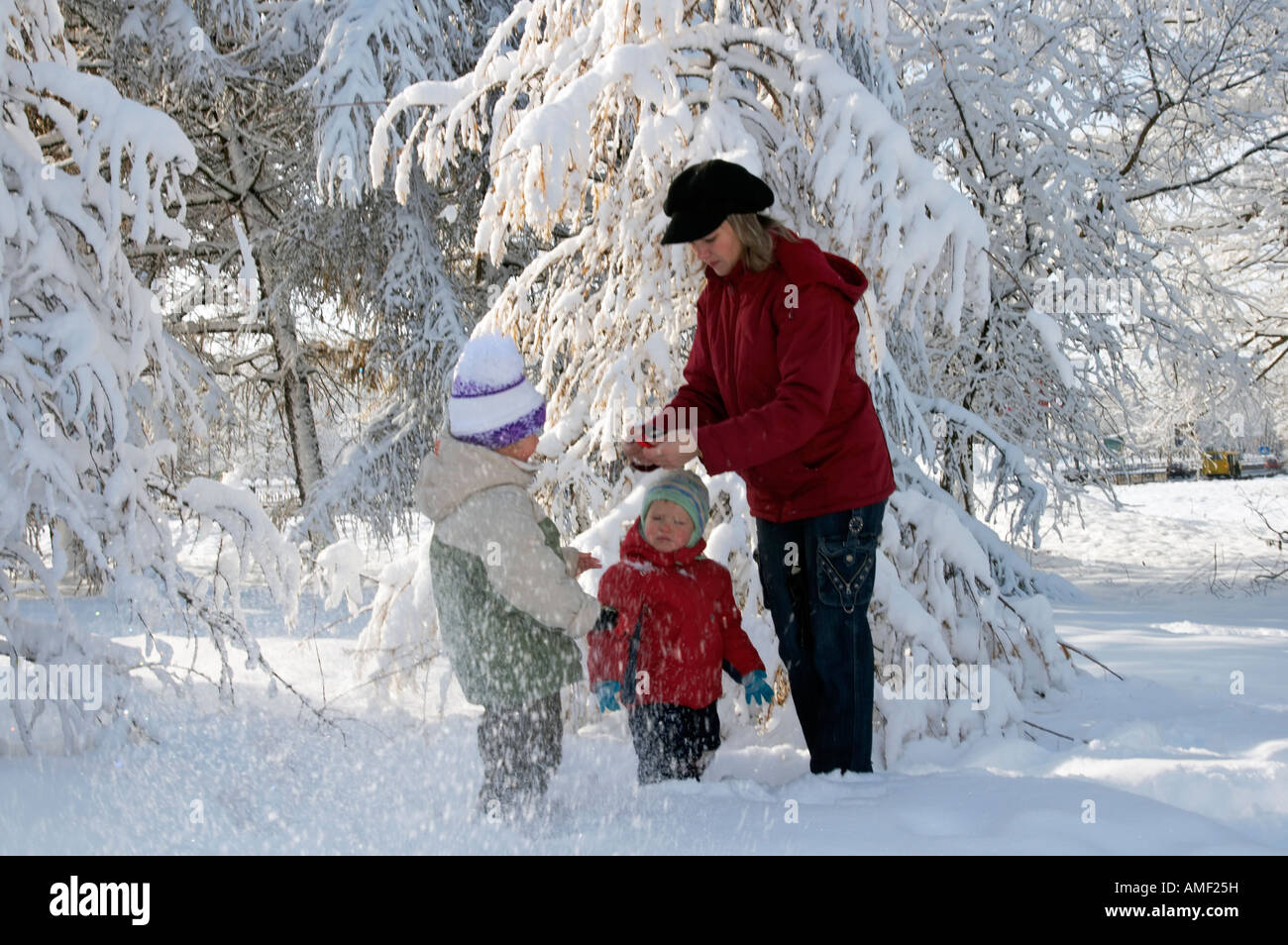 Happy family mother with small boy and girl in winter snow covered city ...