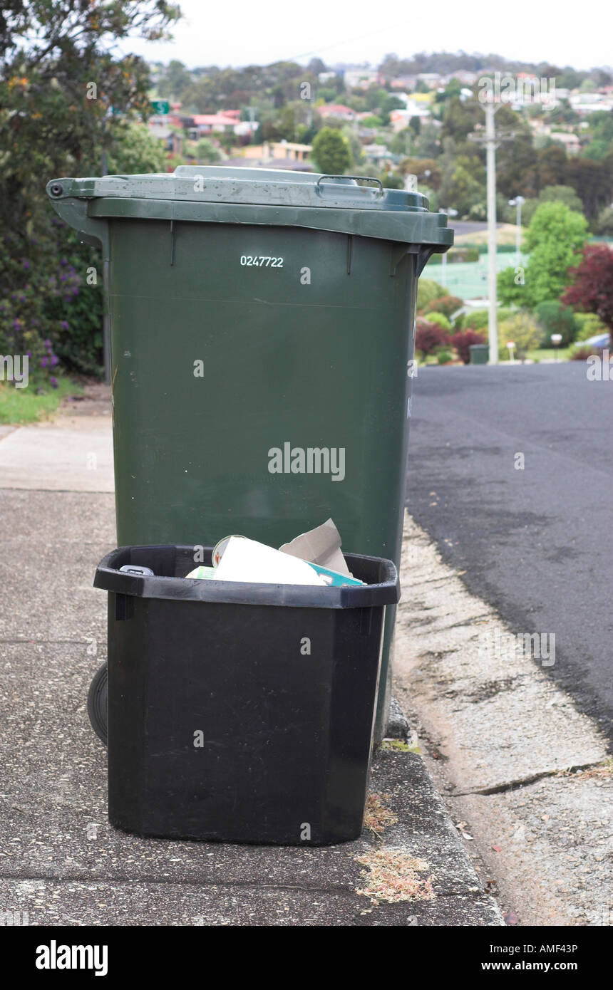 A wheelie bin and black recycling box out on the pavement on bin day