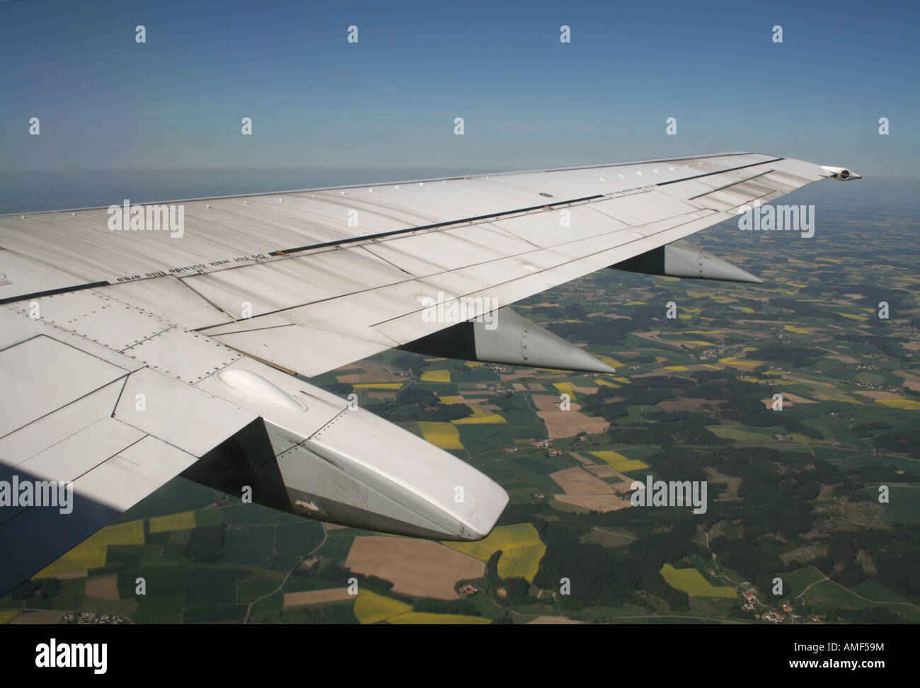 The wing of a Boeing 737-500 airliner in flight over the German countryside. Air travel. Stock Photo
