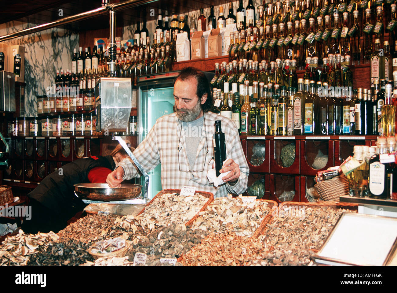 Stallholder selling mushrooms, peppers and olive oil, Mercat St Josep de la Boqueria, La Rambla, Barcelona, Spain Stock Photo