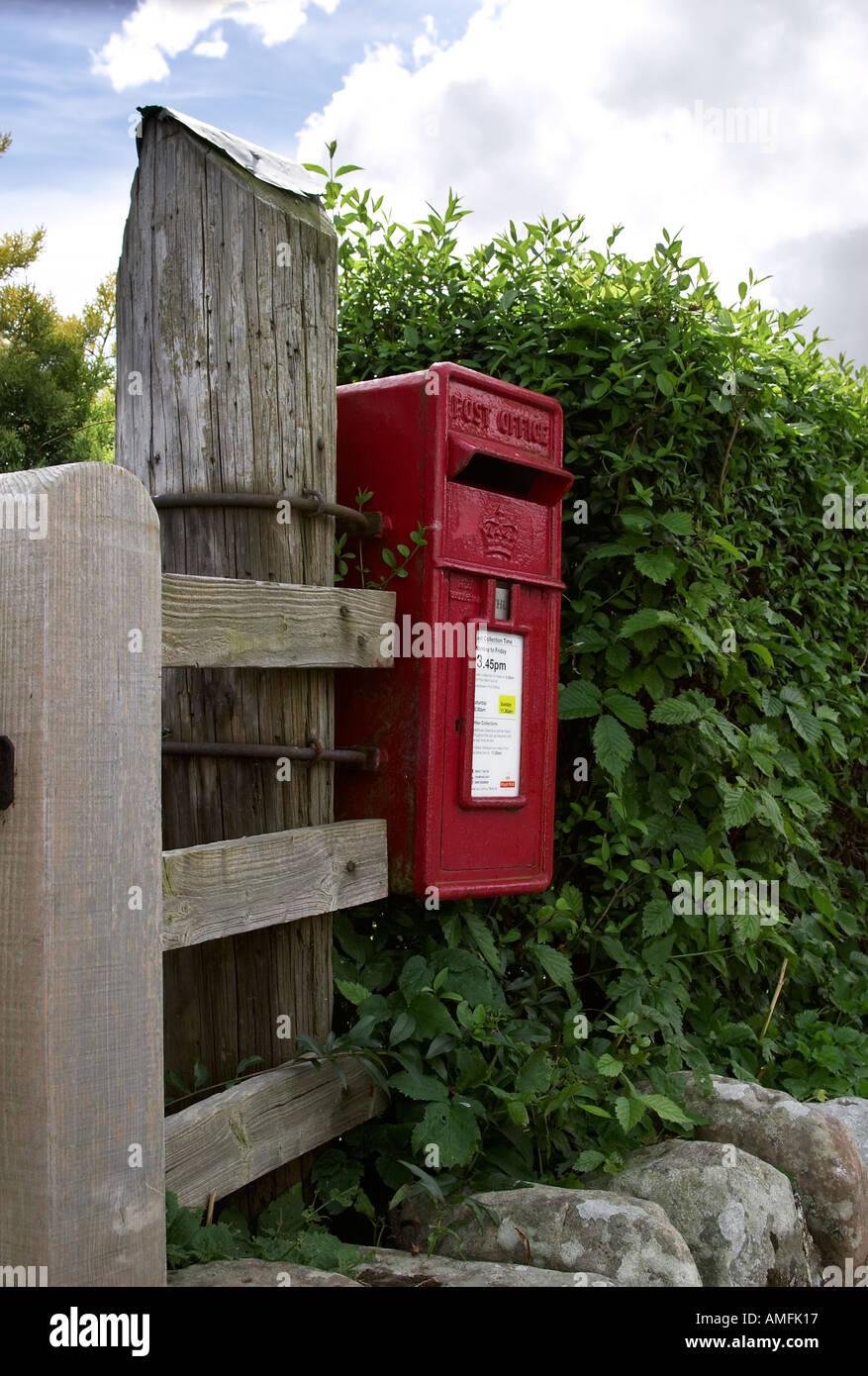 Portrait shot of Red British postal box attached to wooden post with