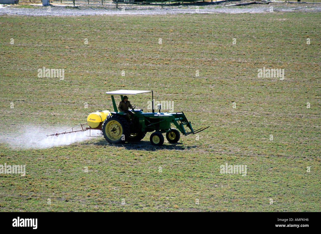 Tractor spraying herbicide on a field. Stock Photo