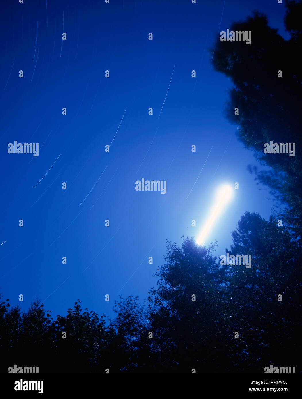 Three hour nightime exposure with moon and stars moving through sky Stock Photo