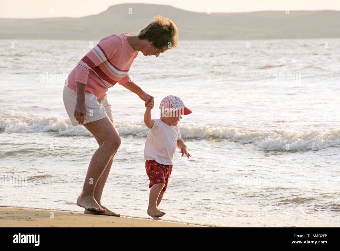 child and mother play on a beach Stock Photo