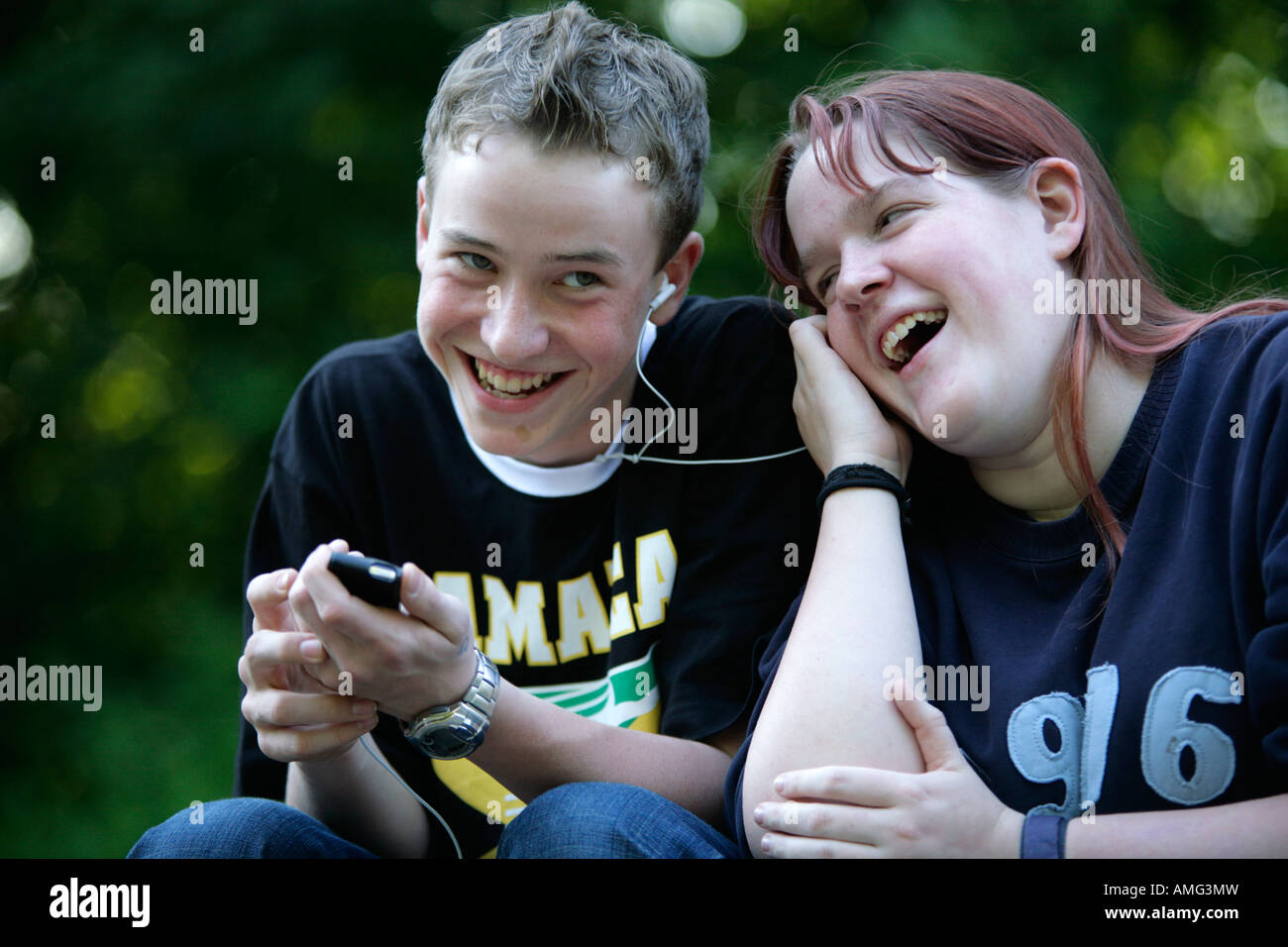 portrait of a teenage boy and a teenage girl listening to music ...
