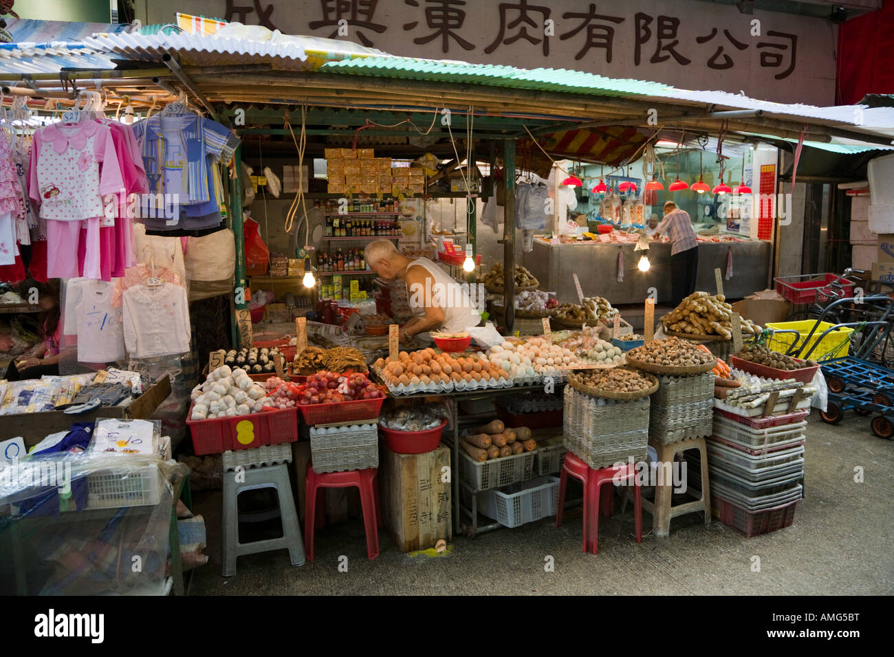 A man prepares a stick of sugar cane in his stall in Wan Chai market