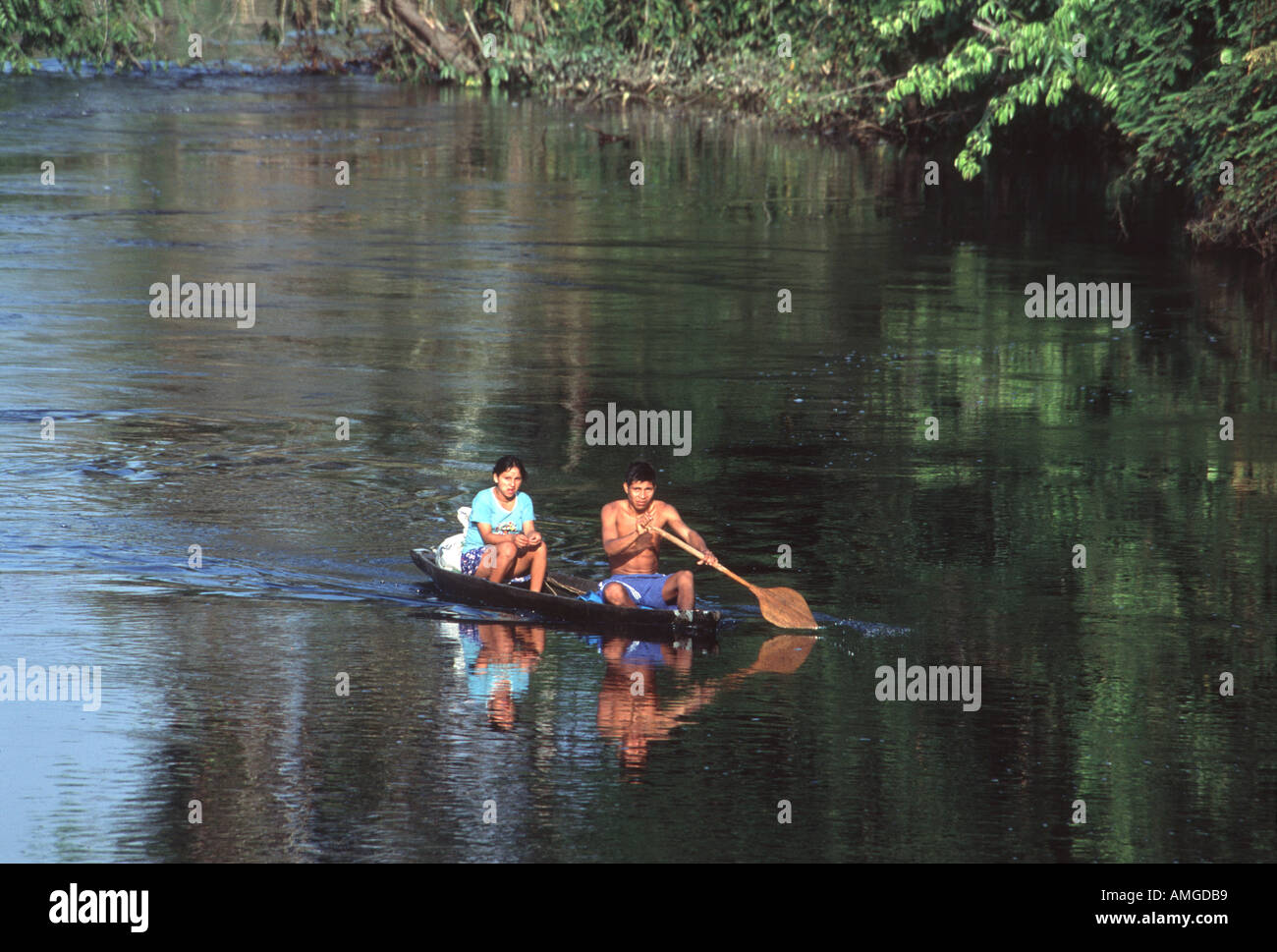 Amazon indians paddle a dugout on the Nanay River Peru Stock Photo