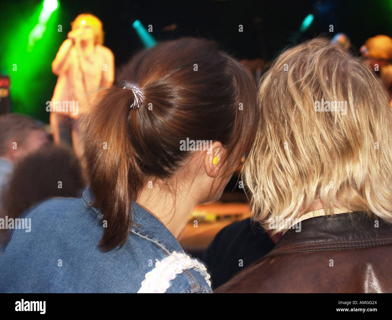 adolescent couple wearing ear protection at rock concert Stock Photo