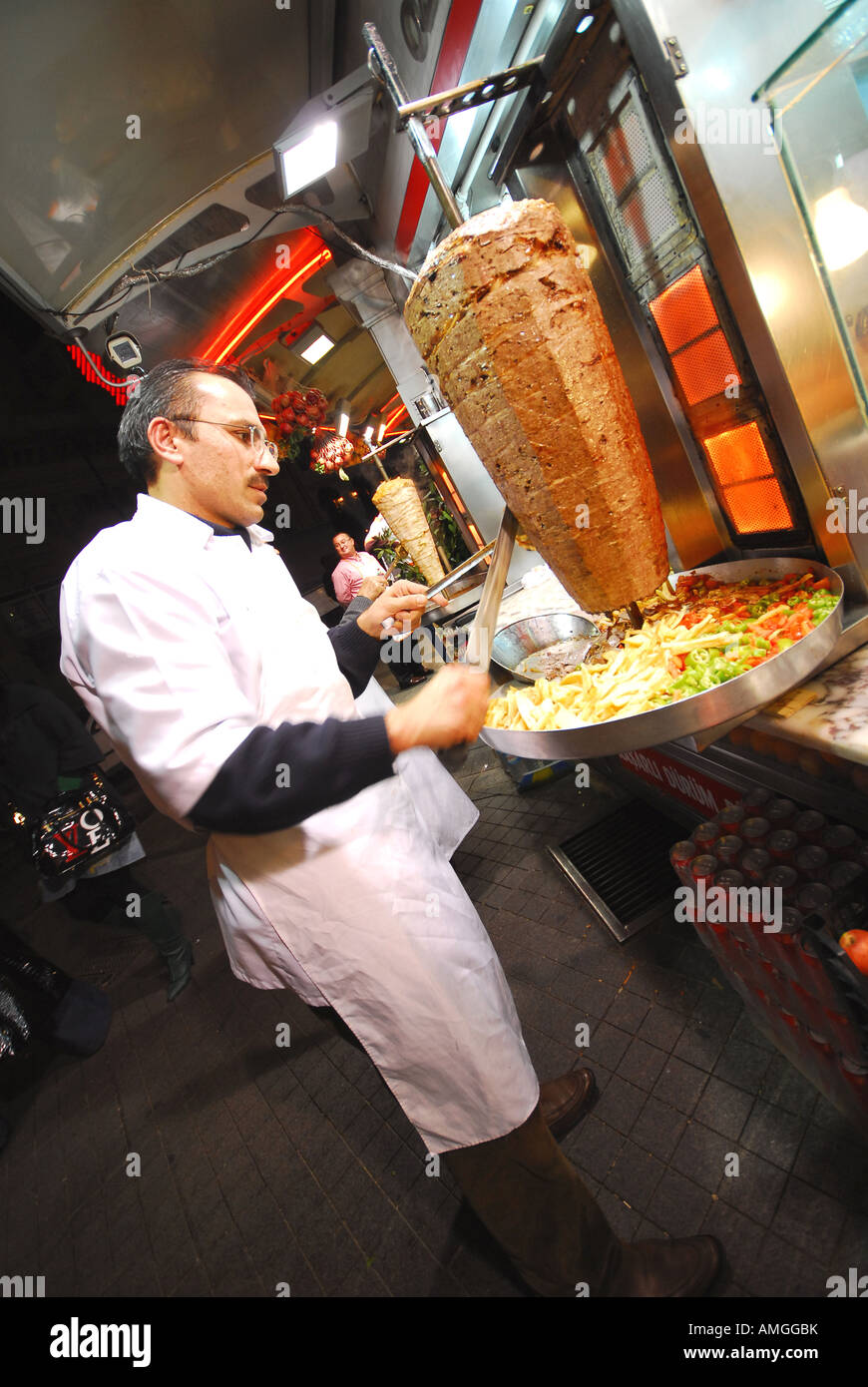 ISTANBUL Man carving lamb kebab at restaurant on Taksim Square at the
