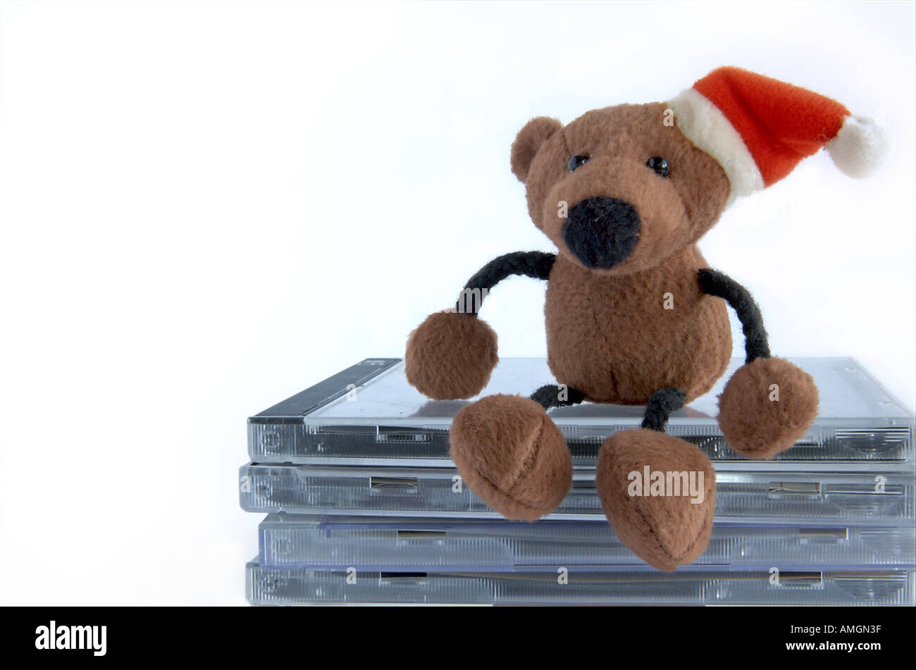 teddy bear sitting on pile of compact discs Stock Photo