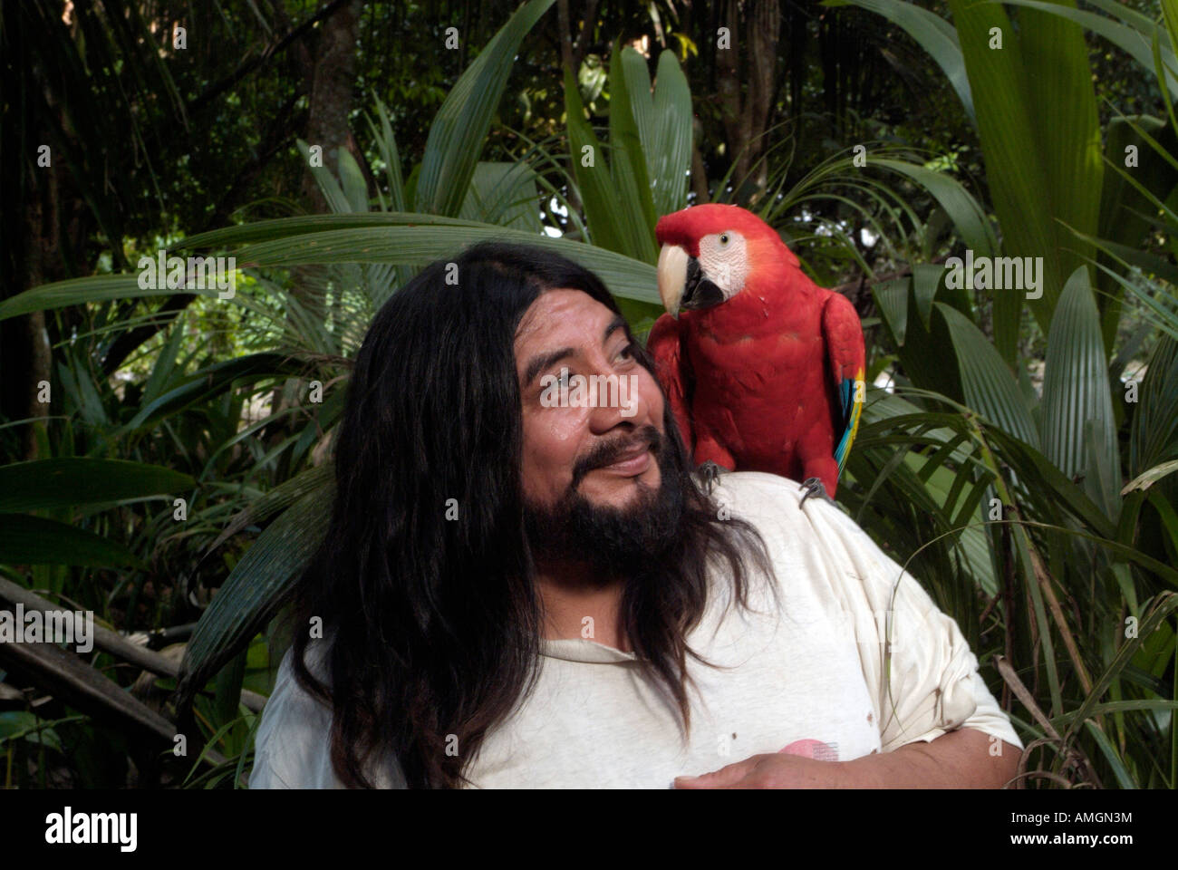 Carmelo Chambor Yuk with pet guacamaya/lapa roja/scarlet macaw (Ara macao) in the Lacandon rainforest. Stock Photo