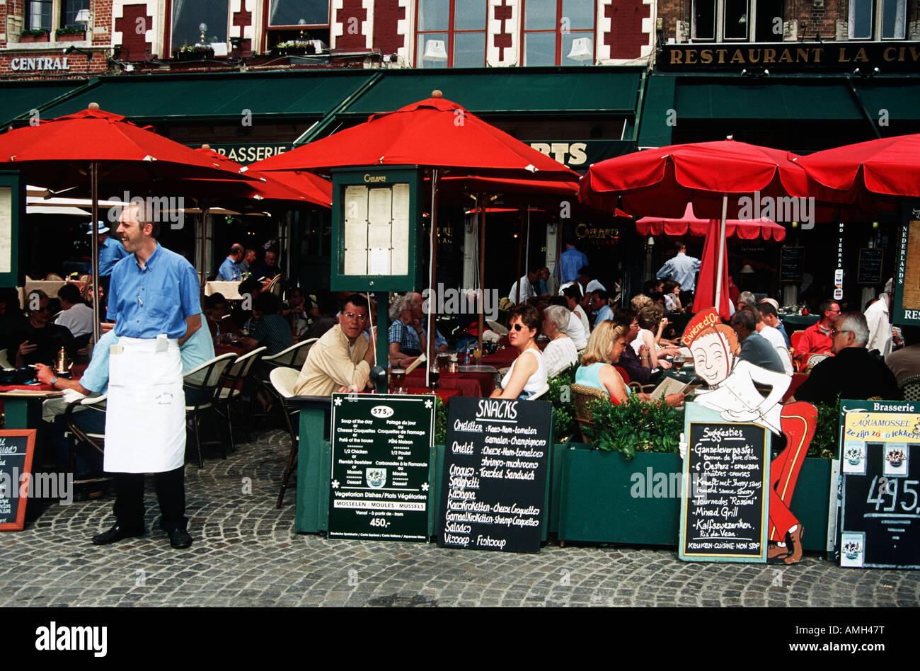Tourists sitting outside restaurant in the Markt, Market Place, Bruges, Belgium Stock Photo