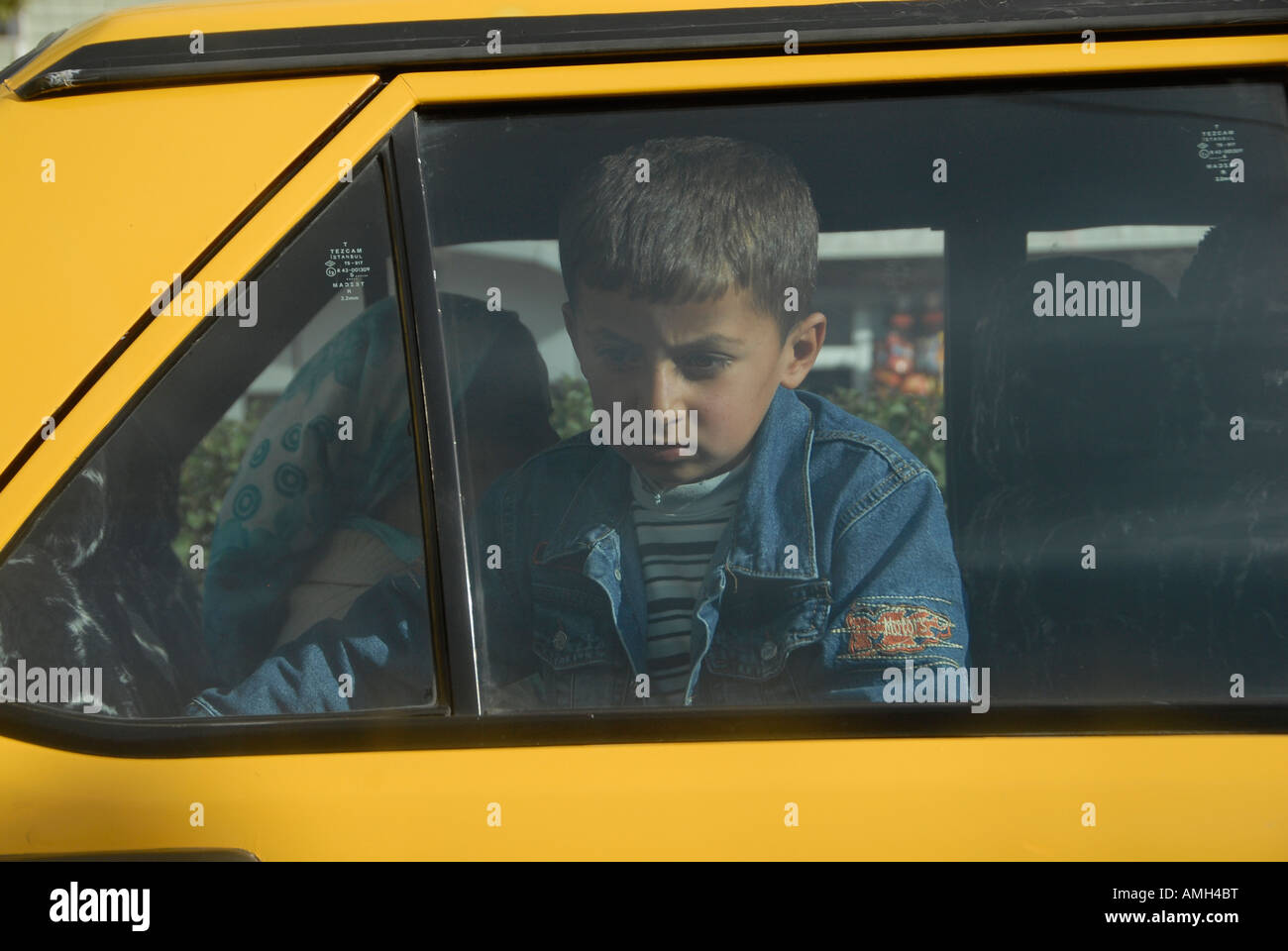 Kurdish boy in a yellow taxi car, Hakkari province, Southeastern Turkey Stock Photo