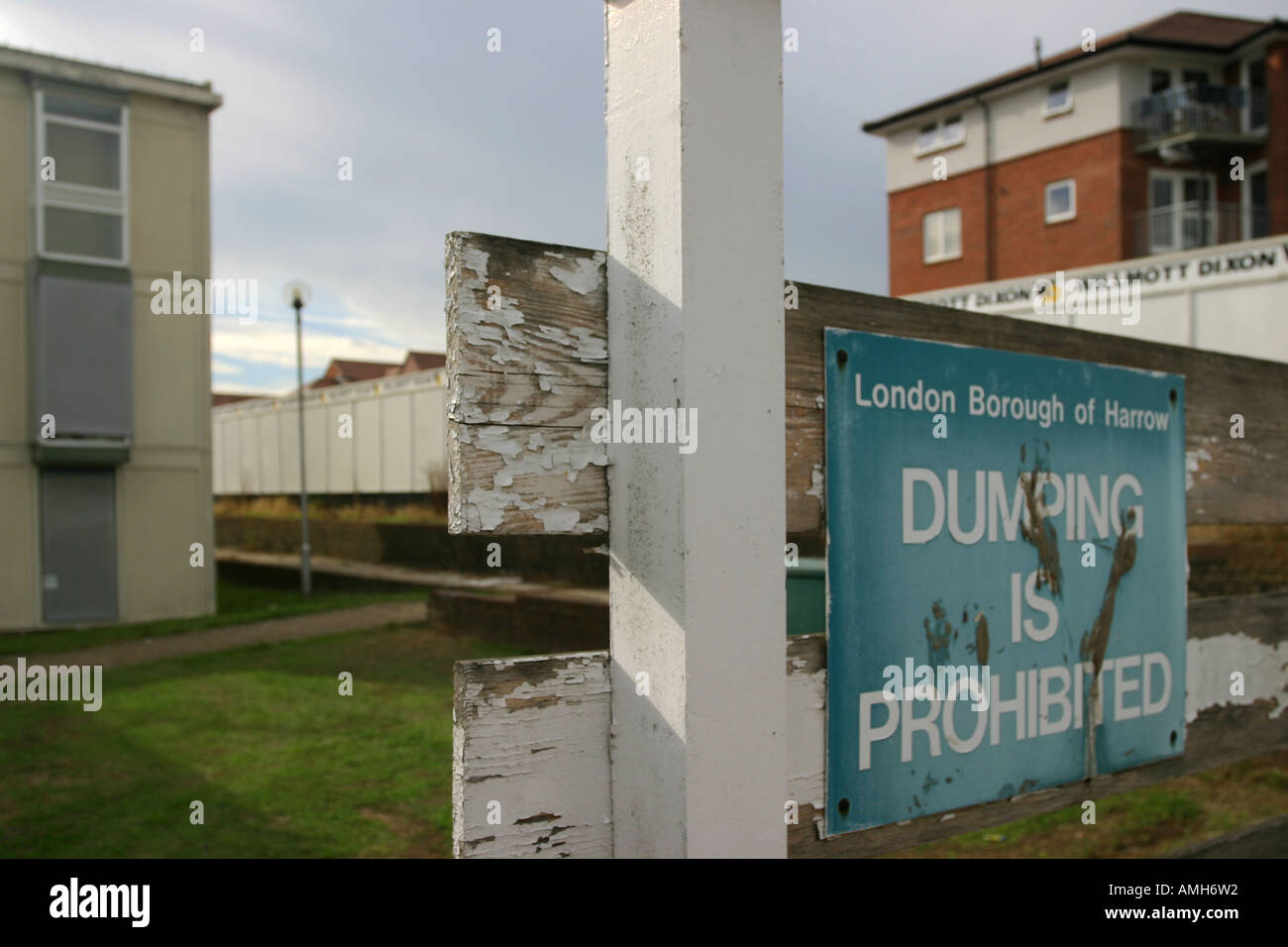 Signage prohibiting dumping with social housing about to be renovated (left) and renovated social housing (right). Stock Photo