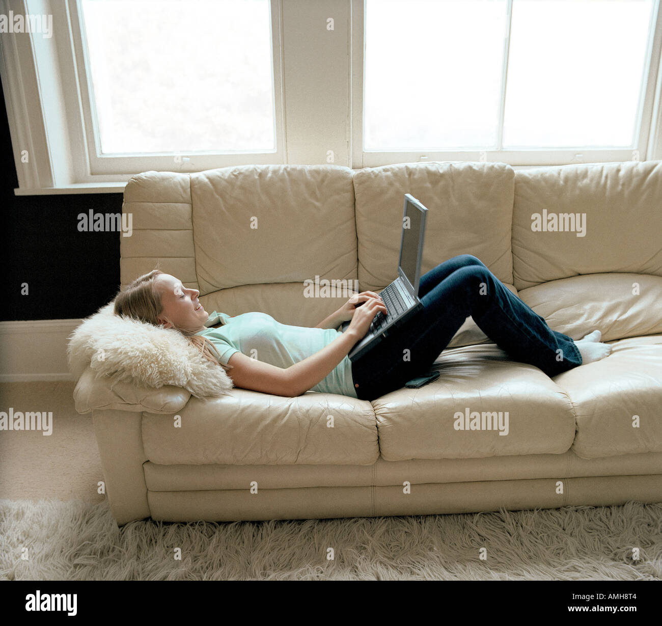 Teenage Girl Lying on Sofa Using Laptop Computer Stock Photo - Alamy