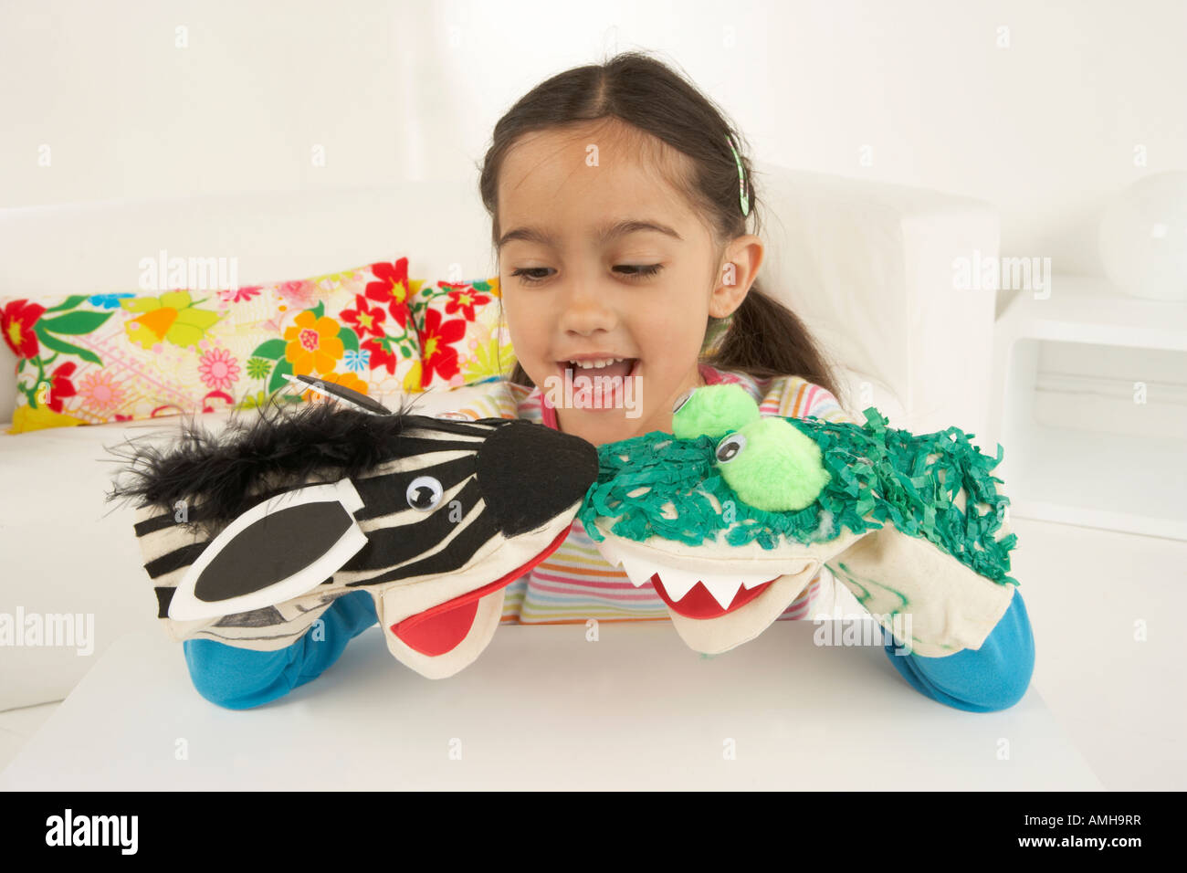 Girl plays with home made animal hand puppets in her bedroom Stock Photo