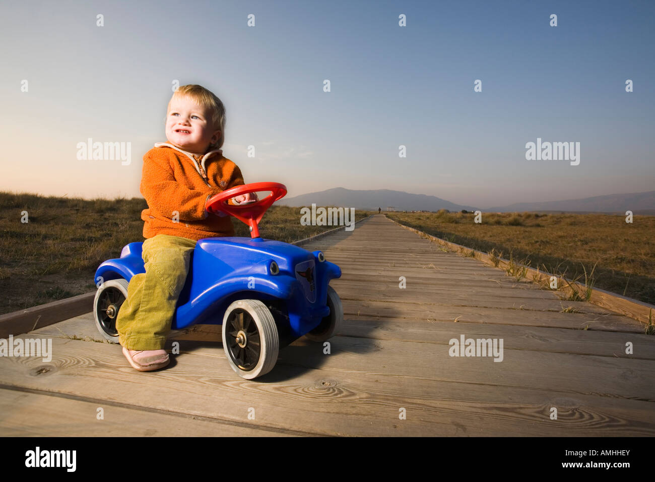 baby with toy car on wood path Stock Photo